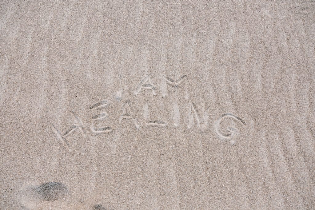 Schrift im Sand: I am healing