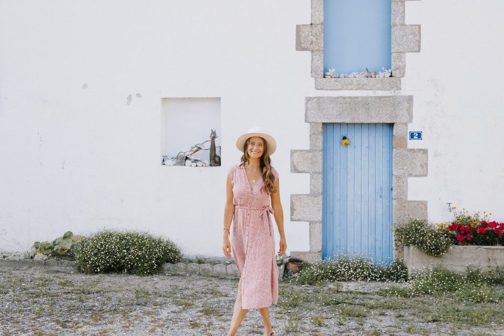 Laura Seiler freudig vor Haus mit blauer Tür
